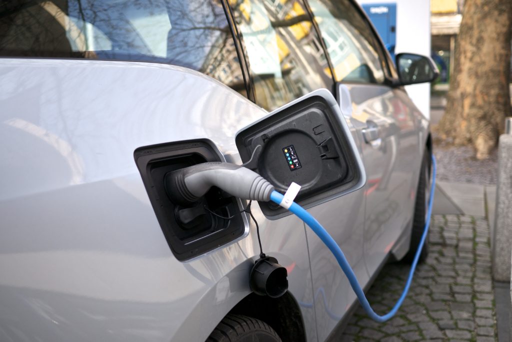 close-up of electric vehicle charger plugged into a white electric vehicle