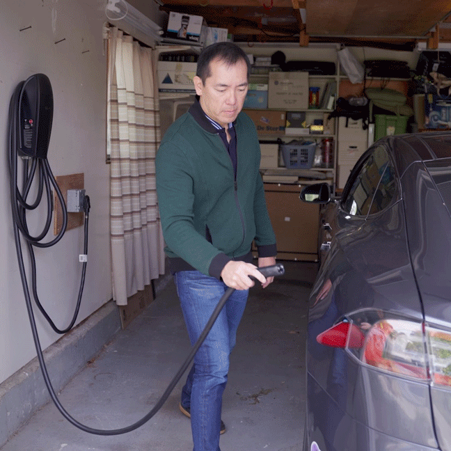 alguien enchufando un coche eléctrico