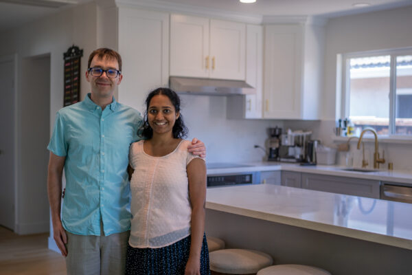 Electric Showcase Award Winner 2023 Full Size-15 Two people posing and smiling in a sleek, electric kitchen