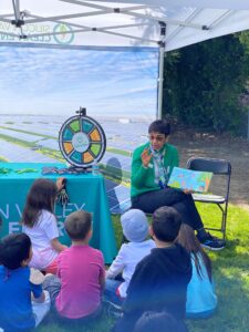 SVCE Board Chair Tina Walia reading a book to a group of students 